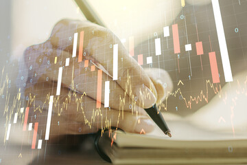 Double exposure of abstract creative financial diagram with world map and with woman hand writing in notepad on background, banking and accounting concept
