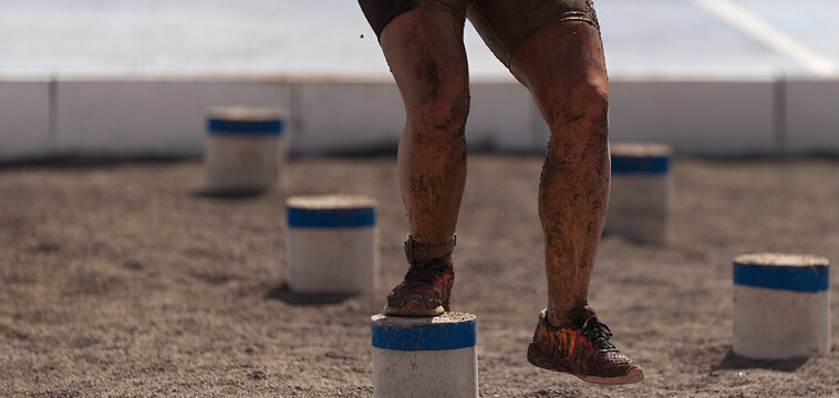Mud race runners. The participante overcoming the obstacle