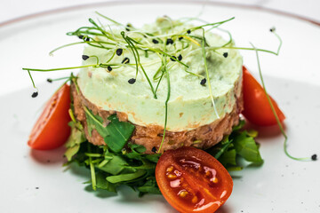 Raw salmon, avocado purple onion salad, delicious avocado and salted salmon tartar, served with arugula, Restaurant menu, dieting, cookbook recipe top view