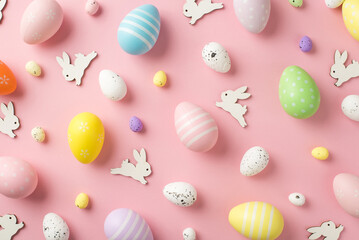 Fototapeta na wymiar Top view photo of easter decorations easter bunnies and multicolored eggs on isolated pastel pink background