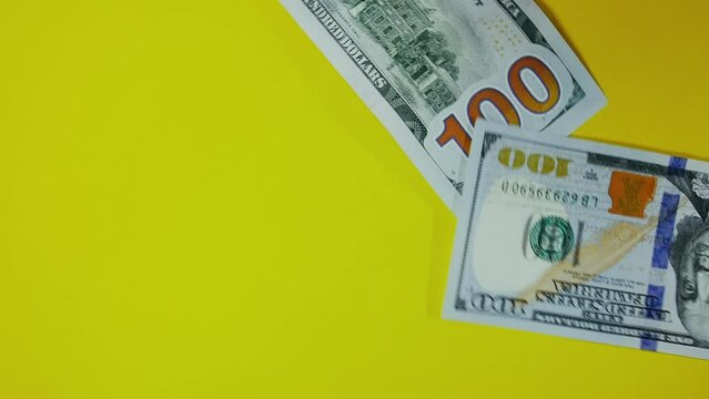 The dollar spin rotate quickly fast fly, dispart, splash to the sides with centrifugal coriolis force. The video is in reverse. Dollar twist, create pattern, make design shape circle picture.