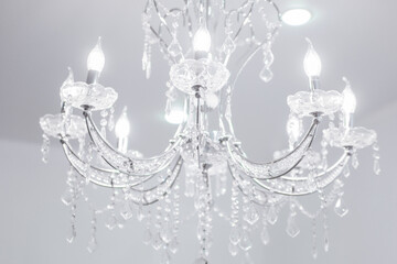 A large beautiful crystal chandelier in the living room against a white ceiling.