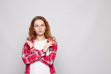red-haired young girl in a plaid shirt on a white background with a place for text shows NO