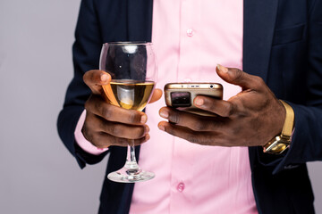 holding glass of wine and using phone
