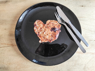 Heart shaped pancake on black plate