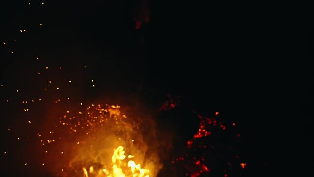 Bonfire in nature. Fire space close up view. Bright stream burn sparks are fly in the camera, at you, into the lens. Slow motion magic cinematic bokeh beautiful flame. Fire defocus, Blur, Bokeh.