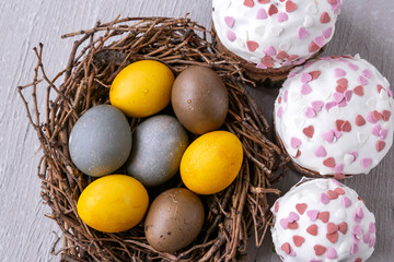 Delicious Easter cakes and dyed eggs top view. Happy Easter.