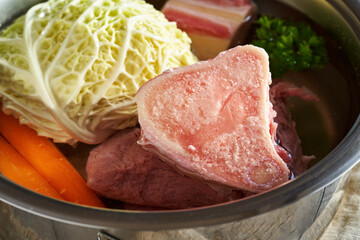 Ingredients to prepare beef bone broth or soup - marrow bones and fresh vegetables