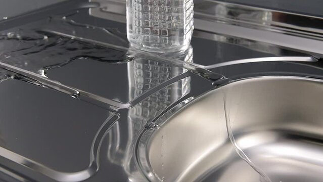 Detail video of water being spiled and drained on stainless steel sink