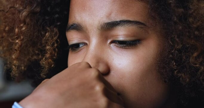 Close up face unhappy 18s African teenage girl, thinking, looks concerned due to life troubles. First love, unrequited feelings, experiences heartbreak, psychological problems, low self-esteem concept
