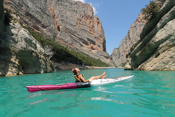 Relaxed woman on kayak resting and breathing in a lake