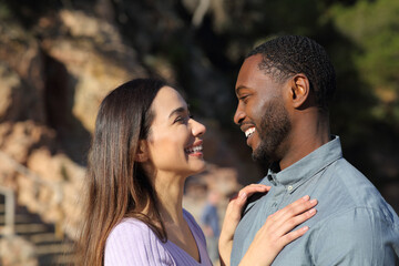 Happy interracial couple flirting in love looking each other