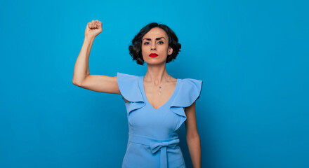 Fototapeta premium Women's rights. Feminism. Equality of gender. Powerful serious strong conceptual woman feminist shows her biceps and fist. International womens day