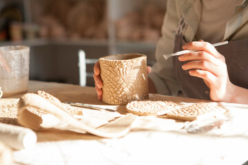 Close up of hands of unrecognizable woman making ceramic mug at pottery stusio