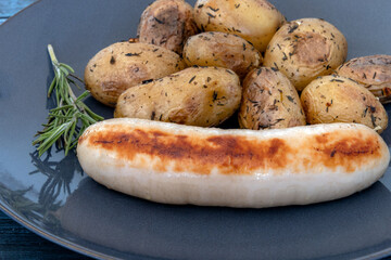 new potatoes with a white pudding in a plate on a gray background