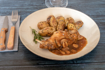 new potatoes with mushroom rabbit in a plate on a gray background