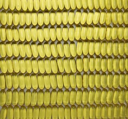 lots of yellow omega 3 oil pills lined up in rows and columns, healthy supplementation