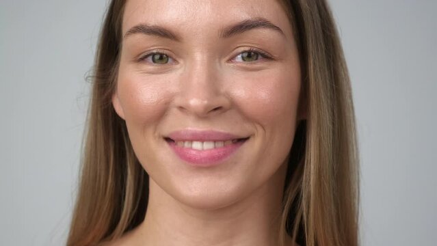 Beautiful young woman with perfect skin. Portrait on the shoulders. Spa, health and skin care. Advertising of cosmetics. Gray background.