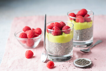 Chia pudding with avocado and raspberries in glass. Healthy vegan dessert, breakfast or snack