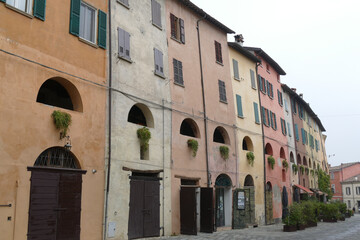 Fototapeta na wymiar Colorful buildings in Brisighella with the arched windows of the elevated “donkey road”