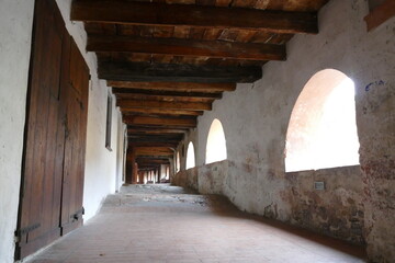 The ancient elevated covered “donkey road” in Brisighella built inside the buildings has ceiling with wooden beams and arched windows 