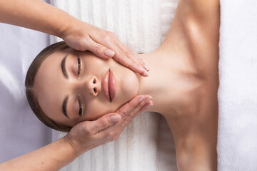 Obraz na płótnie Canvas Massage therapist massaging woman face
