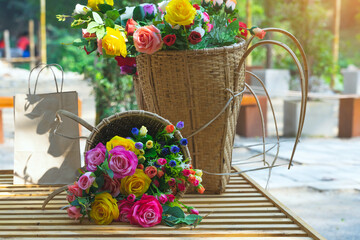 Fototapeta na wymiar Beautiful bouquet roses flower artificial in vintage wicker basket. Artificial multicolor flowers made from cloth or fabric look like real flower. Retro style.Valentines Day concept. Selective focus.
