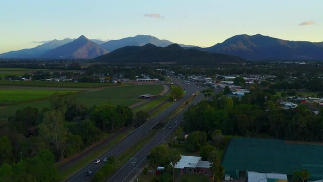 Beautiful Scenery Of Asphalt Road With Mountain Ranges At Background In Rural Town Of Cairns, QLD Australia. Aerial