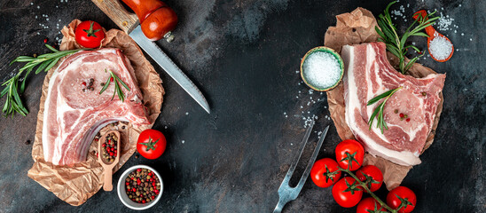 Organic Pork meat chop set with spices and rosemary and red pepper on black table. Long banner format. top view