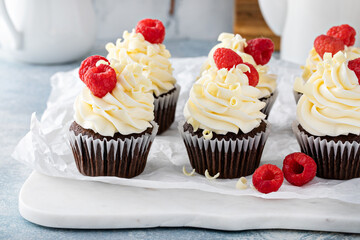 Chocolate cupcakes with white chocolate frosting and raspberries
