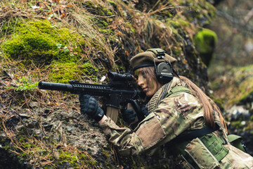 Taking cover while firing actively on ground female guard soldier . High quality photo