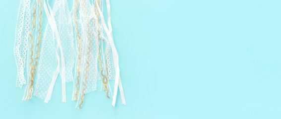 Image of white lace ribbons over blue pastel background