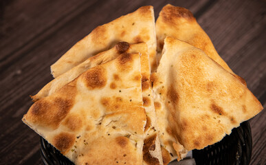 Food photography. Close up view with focaccia bread against a wooden table.