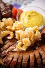 Traditional Romanian food. Close up view of a food plate made of pork meat against a wooden background.