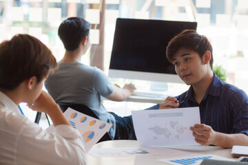 The concept of human relations with colleagues. The young man smiled and happily worked with his colleagues.