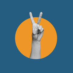 Female hand showing a peace gesture isolated on a dark blue with orange circle color background....