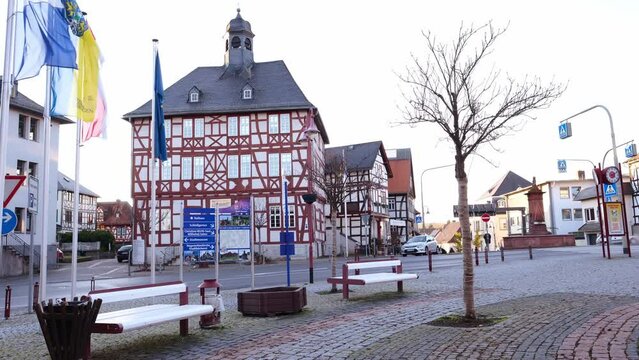 Usingen, Germany, November 2021: European medieval architecture of modern city in half-timbered style, cars driving on road in city center, concept of cultural tourism, travel, excursions in old town