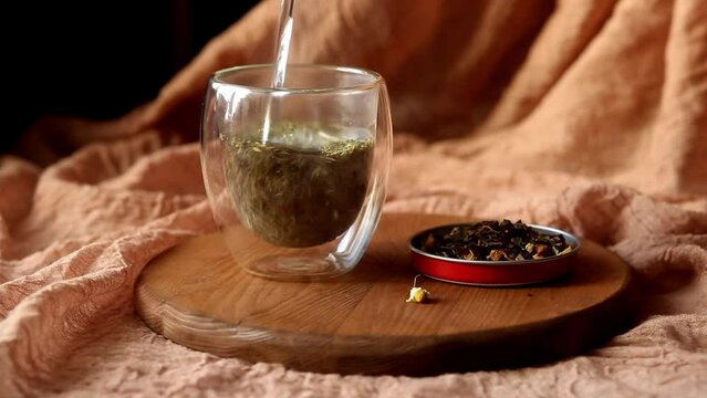 Brew dry herbal aromatic tea in a glass cup. Pour boiling water over tea. Steam over a cup of tea