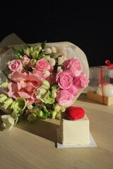 wedding bouquet of pink fresh roses and gift box at daylight.