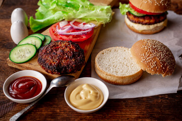 Home cooking hamburger or cheeseburger. Different ingredients for a classic hamburger. Wooden background. Food concept.