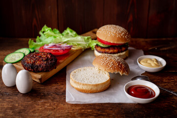 Home cooking hamburger or cheeseburger. Different ingredients for a classic hamburger. Wooden background. Food concept.