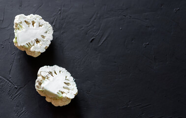 Cauliflower cut in half on a dark background. Vegetarian food, diet concept.