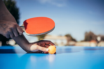 Hands holding a table tennis racket ready to serve