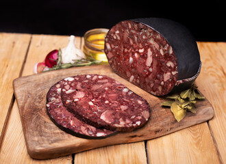Black brawn, blood sausage, black pudding on a wood cutting board, close up. Polish cold cuts, meat...