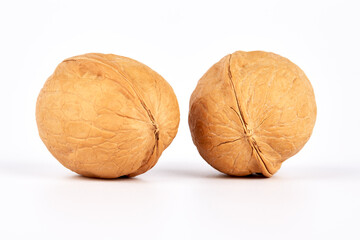 Two whole inshell walnuts on a white background