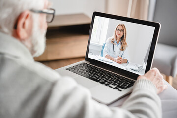 Fototapeta na wymiar Old elderly pensioner man grandfather having videocall conversation meeting virtual conference with a doctor telling about health problems on laptop remotely, telemedicine concept