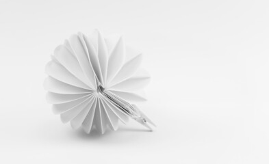 Białe tło z okrągłą, papierową, dekoracją przypominającą kwiat, fantazyjny wzór.