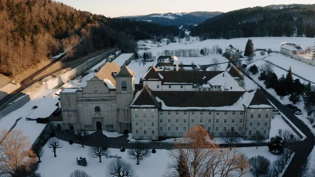 The abbey of Bellelay, historical monument of the Bernese Jura in Switzerland, aerial shot by drone during sunrise