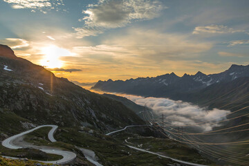 Sunrise over the mountains with low clouds in the valley in NufenenPass SwissPass