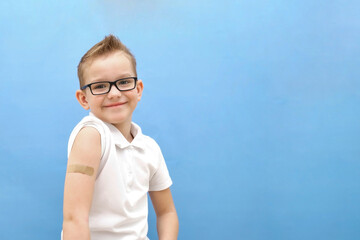funny boy with glasses on a blue background.  He was given a vaccine against the disease,...